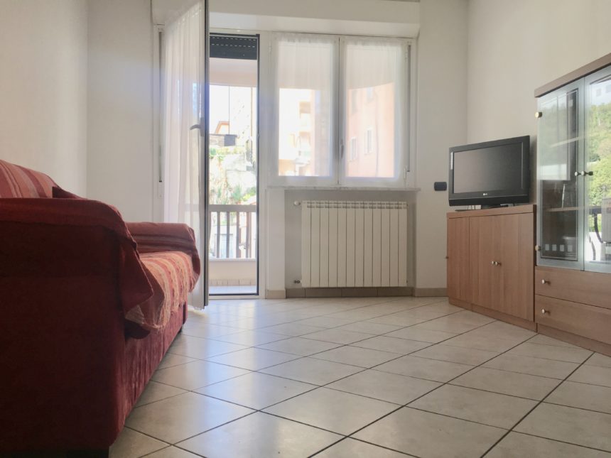 Bilocale in affitto a Cogoleto. Soggiorno con divano letto e terrazzo.